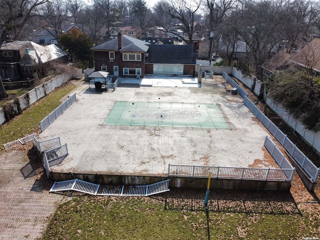 rear view of property featuring a covered pool and a patio area