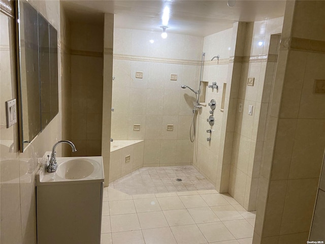 bathroom featuring a tile shower, tile patterned flooring, vanity, and tile walls