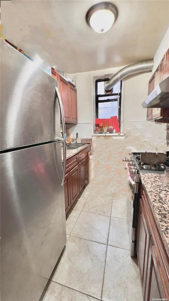 kitchen featuring appliances with stainless steel finishes, ventilation hood, and light stone counters