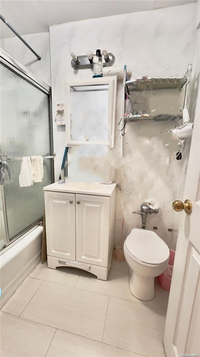 bathroom with shower / bath combination with glass door, tile patterned floors, and toilet