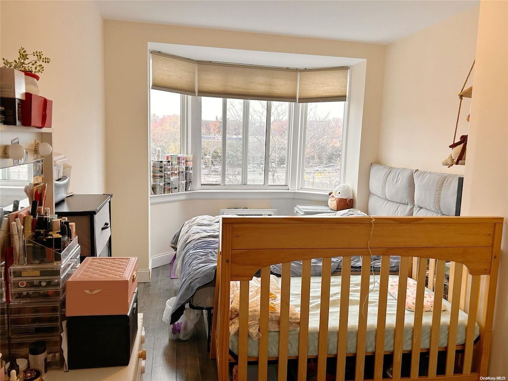 bedroom with hardwood / wood-style floors and multiple windows