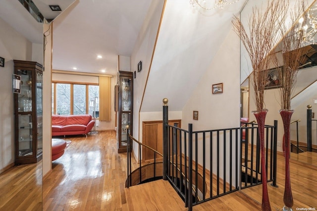 hallway featuring hardwood / wood-style flooring and an inviting chandelier