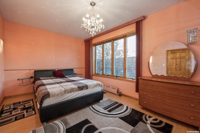 bedroom featuring a chandelier, light hardwood / wood-style flooring, and a baseboard radiator