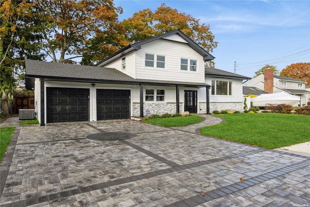 view of front of home featuring a front yard, a garage, and cooling unit