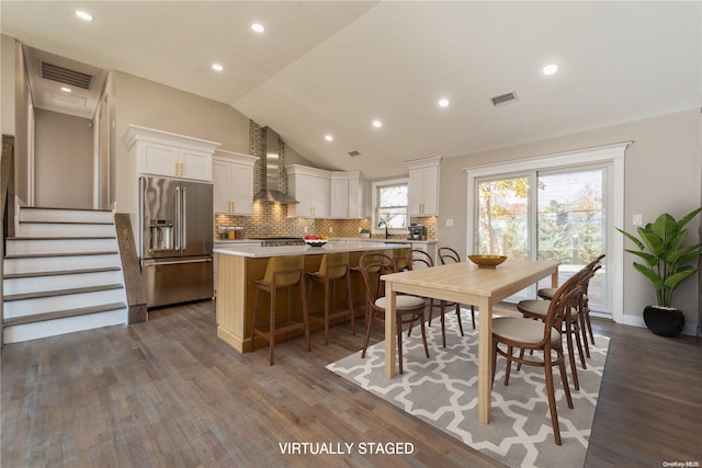 dining space featuring dark wood-type flooring, lofted ceiling, and sink