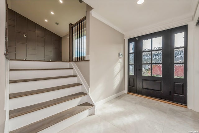 tiled entrance foyer with a healthy amount of sunlight, lofted ceiling, and crown molding