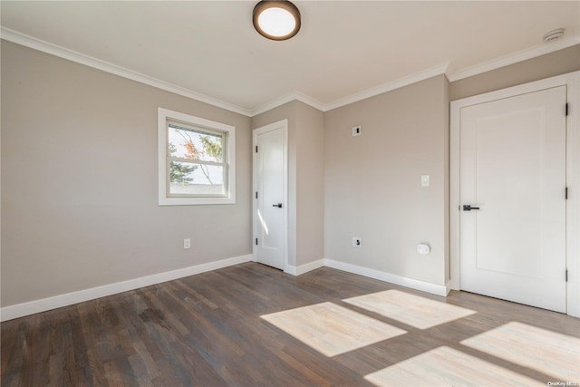 empty room with dark hardwood / wood-style flooring and ornamental molding