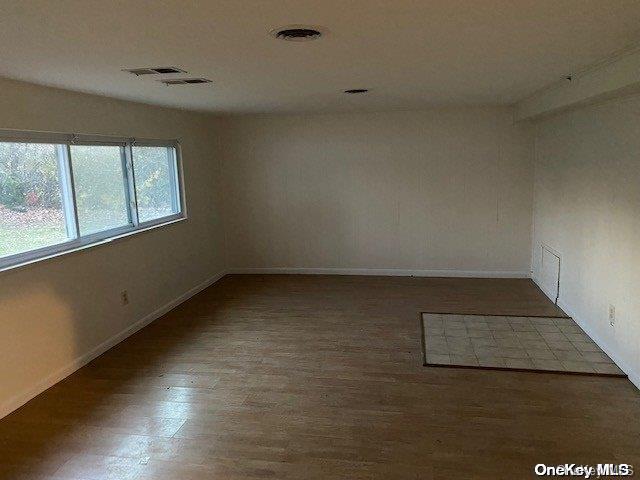 unfurnished room featuring hardwood / wood-style flooring and lofted ceiling