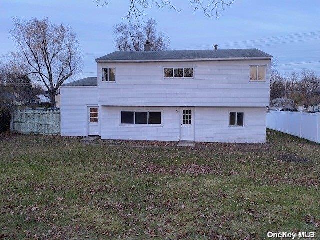 rear view of house featuring a yard