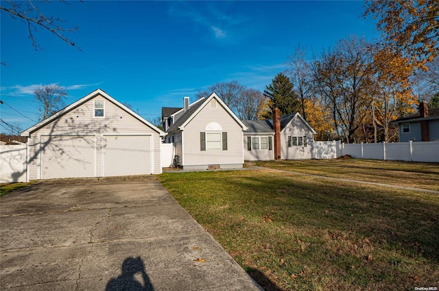 view of front facade featuring an outbuilding, a garage, and a front lawn