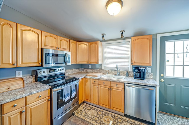 kitchen featuring light stone counters, sink, light brown cabinets, and appliances with stainless steel finishes