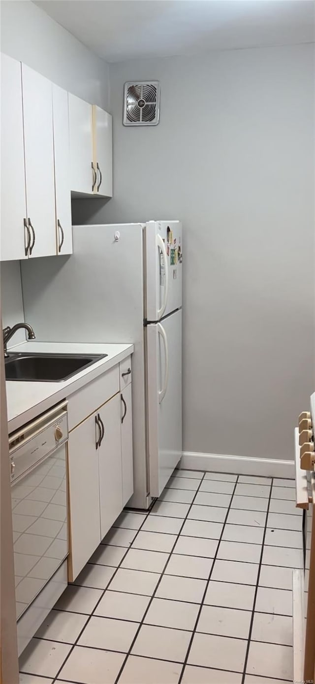 kitchen with dishwasher, light tile patterned floors, white cabinetry, and sink