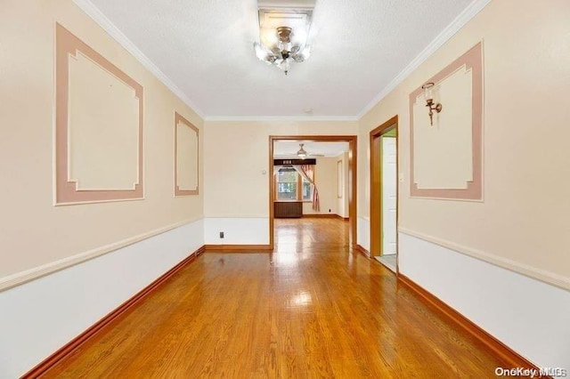 hall with wood-type flooring and ornamental molding