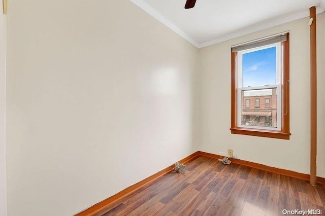 empty room featuring ceiling fan, wood-type flooring, and ornamental molding