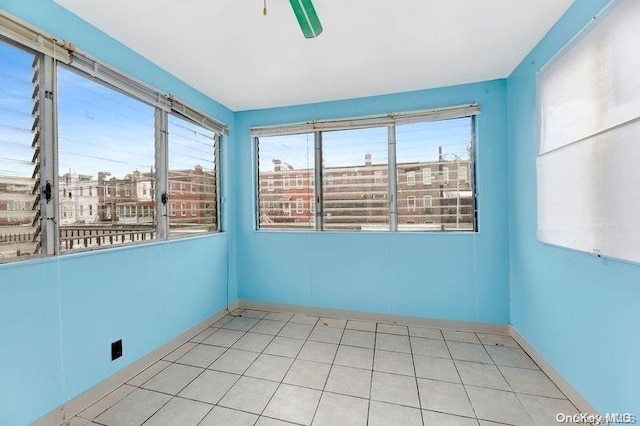 empty room featuring ceiling fan and light tile patterned floors