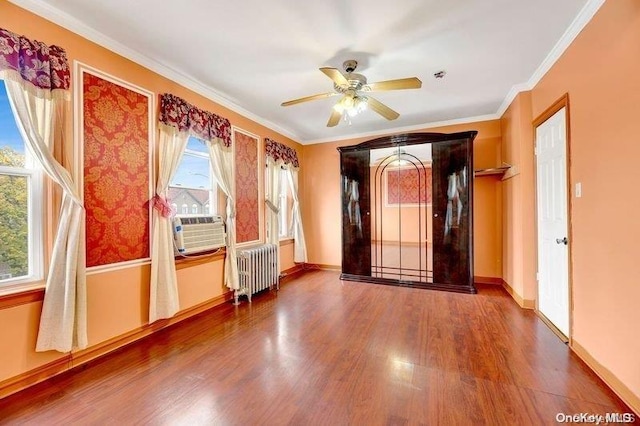 unfurnished room featuring ceiling fan, radiator heating unit, crown molding, cooling unit, and wood-type flooring