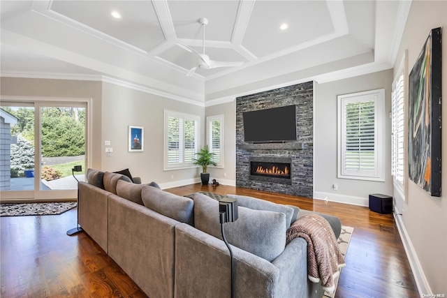 living room with dark wood-type flooring, a fireplace, ornamental molding, ceiling fan, and coffered ceiling