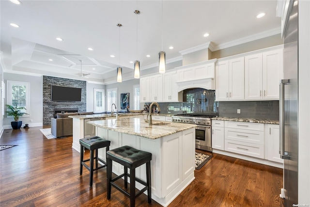 kitchen featuring white cabinets, sink, high quality appliances, and pendant lighting