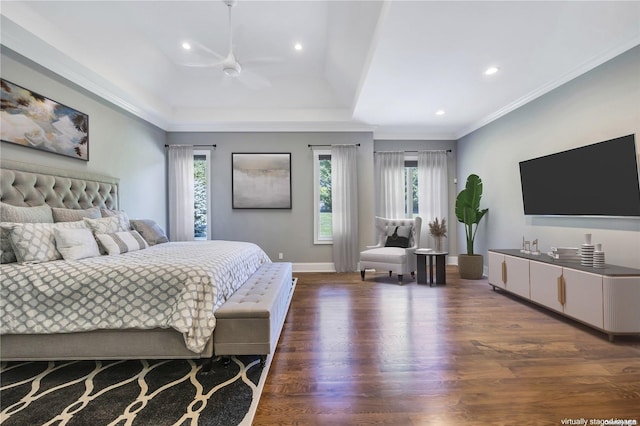 bedroom featuring crown molding, dark hardwood / wood-style floors, a tray ceiling, and multiple windows