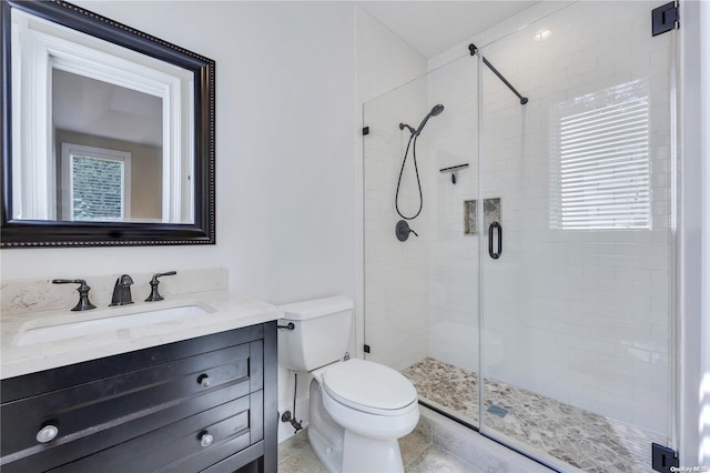 bathroom featuring a shower with shower door, vanity, tile patterned floors, and toilet