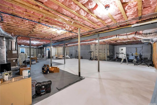 basement featuring heating unit and water heater