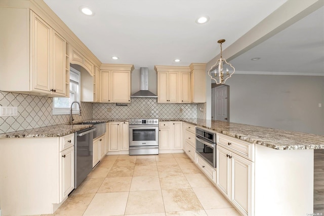 kitchen featuring stone countertops, wall chimney range hood, decorative light fixtures, kitchen peninsula, and stainless steel appliances