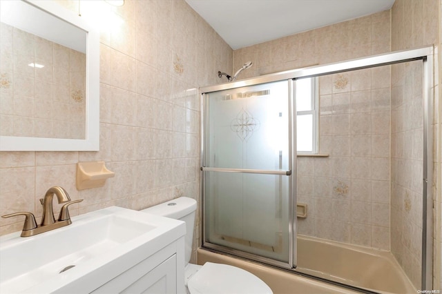 full bathroom with vanity, combined bath / shower with glass door, decorative backsplash, toilet, and tile walls