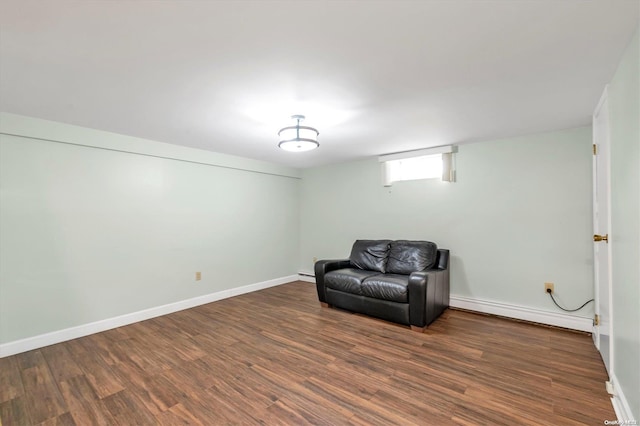 living area featuring a baseboard radiator and dark hardwood / wood-style floors