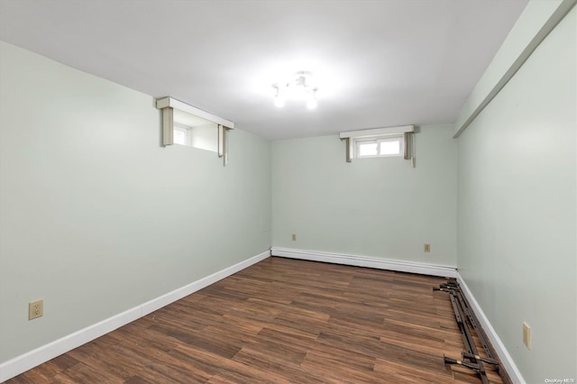 basement featuring dark wood-type flooring and a baseboard radiator