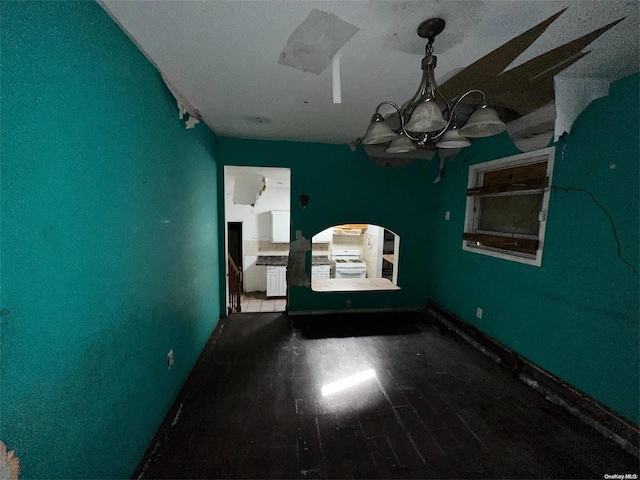 unfurnished dining area with hardwood / wood-style floors and a notable chandelier