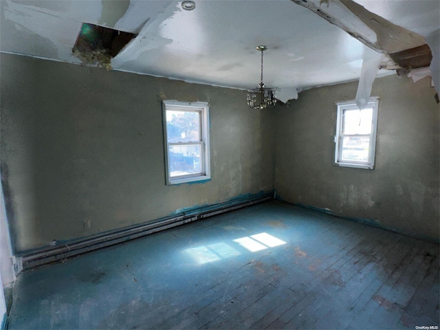 empty room with a chandelier, wood-type flooring, and a wealth of natural light