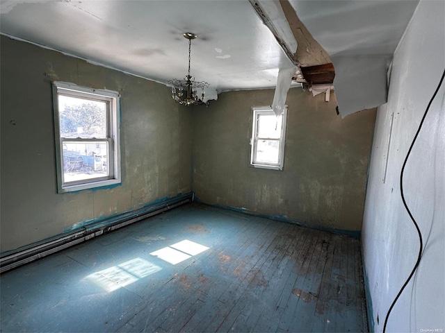 empty room with hardwood / wood-style floors, plenty of natural light, and a notable chandelier