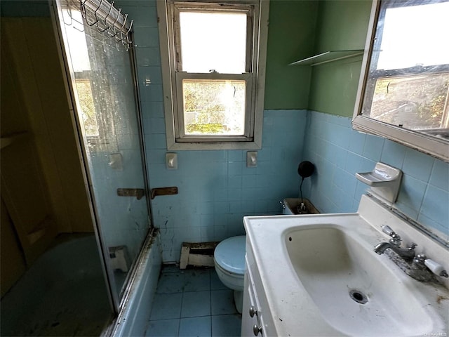 full bathroom with toilet, plenty of natural light, tile walls, and tile patterned flooring