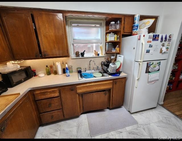 kitchen featuring white fridge and sink