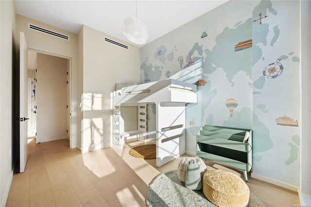 31-16 21st St Unit 3C, Astoria, NY 11106 - bedroom featuring wood finished floors, wallpapered walls, and baseboards
