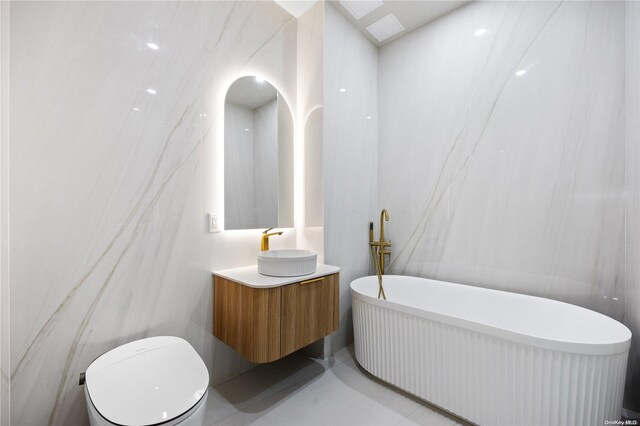31-16 21st St Unit 3C, Astoria, NY 11106 - bathroom with vanity, a freestanding bath, and toilet