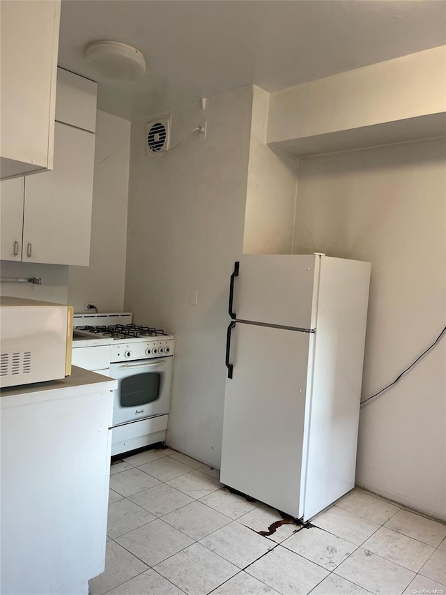 kitchen featuring white cabinetry, white appliances, and light tile patterned floors