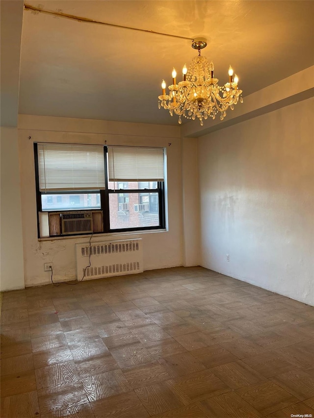 unfurnished room with cooling unit, radiator, and a chandelier