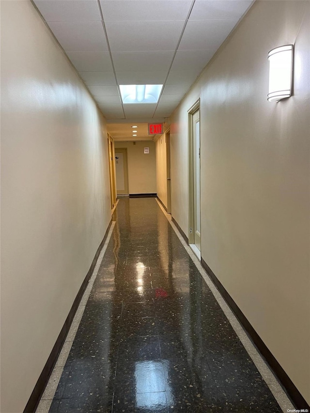 hall featuring a paneled ceiling