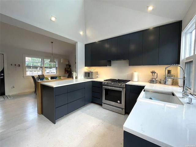 kitchen with kitchen peninsula, stainless steel appliances, sink, decorative light fixtures, and high vaulted ceiling