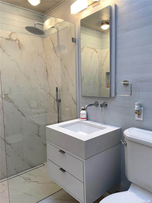 bathroom featuring vanity, toilet, and a tile shower