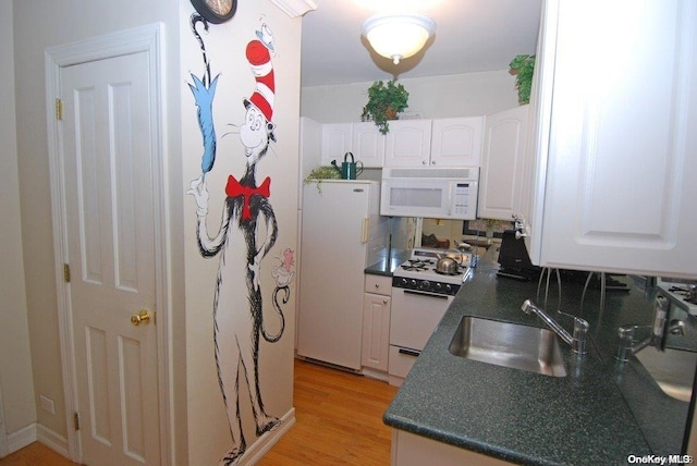 kitchen featuring white appliances, sink, light hardwood / wood-style flooring, tasteful backsplash, and white cabinetry