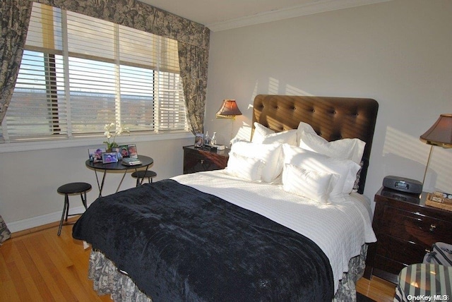 bedroom with light hardwood / wood-style floors, crown molding, and multiple windows