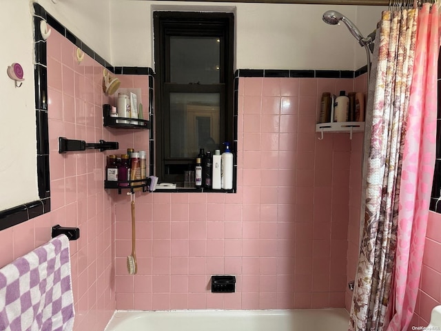 bathroom featuring shower / bath combo and tile walls