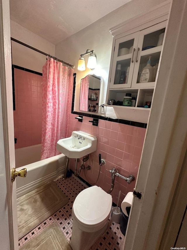 full bathroom with shower / bath combo, tile patterned floors, sink, toilet, and tile walls