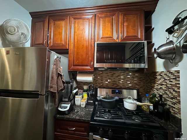 kitchen with decorative backsplash, stainless steel appliances, and dark stone counters