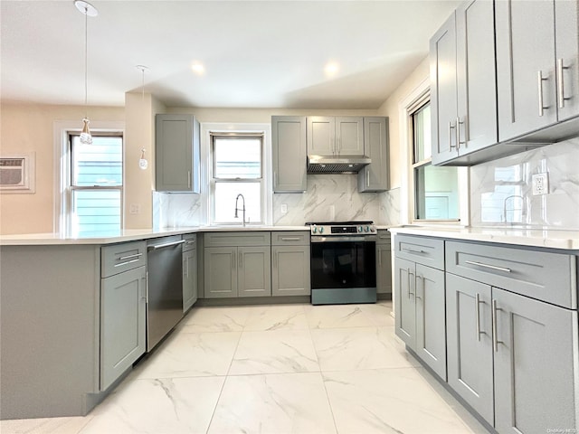 kitchen with sink, hanging light fixtures, gray cabinets, tasteful backsplash, and stainless steel appliances