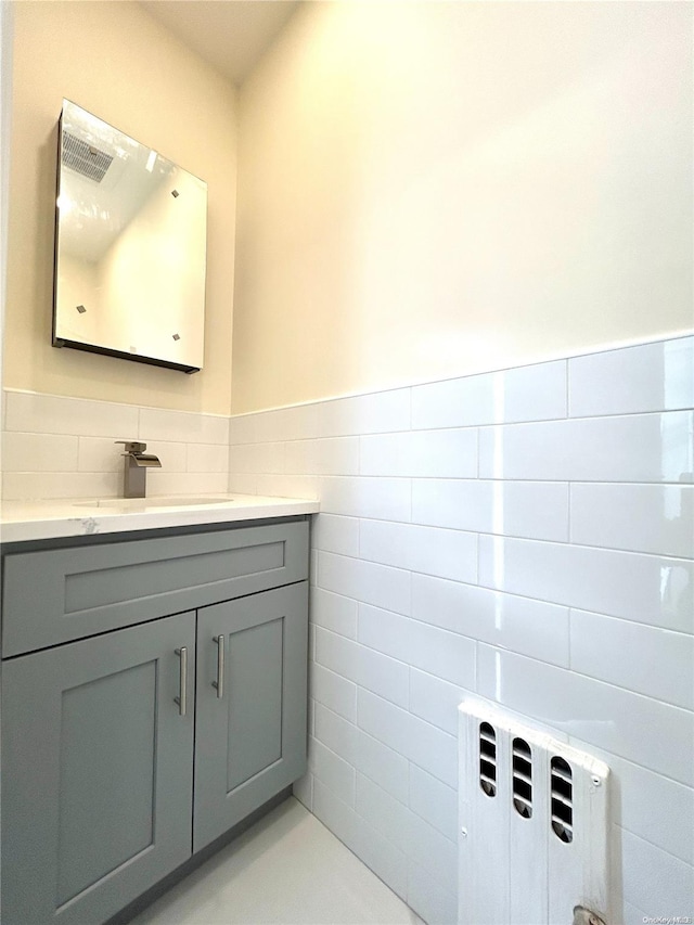 bathroom with vanity and tile walls