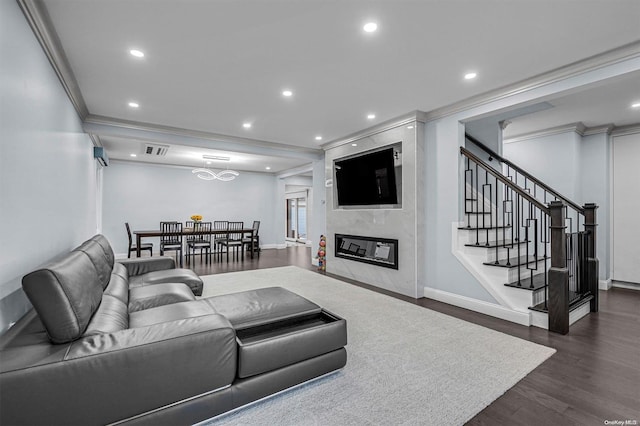 living room with dark hardwood / wood-style flooring, a premium fireplace, and crown molding