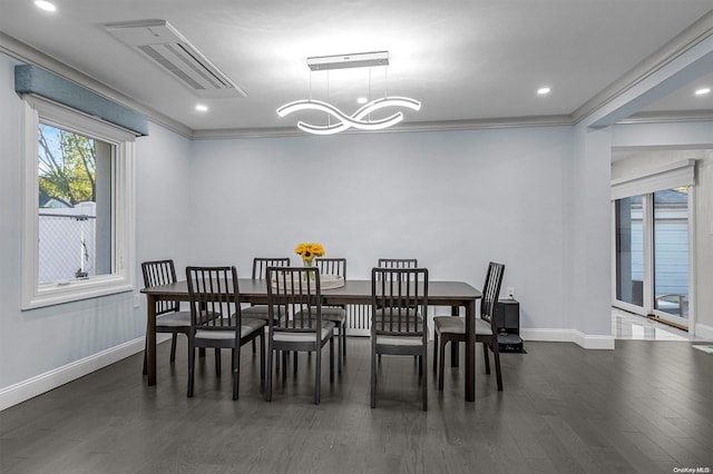 dining space with ornamental molding, dark wood-type flooring, and an inviting chandelier